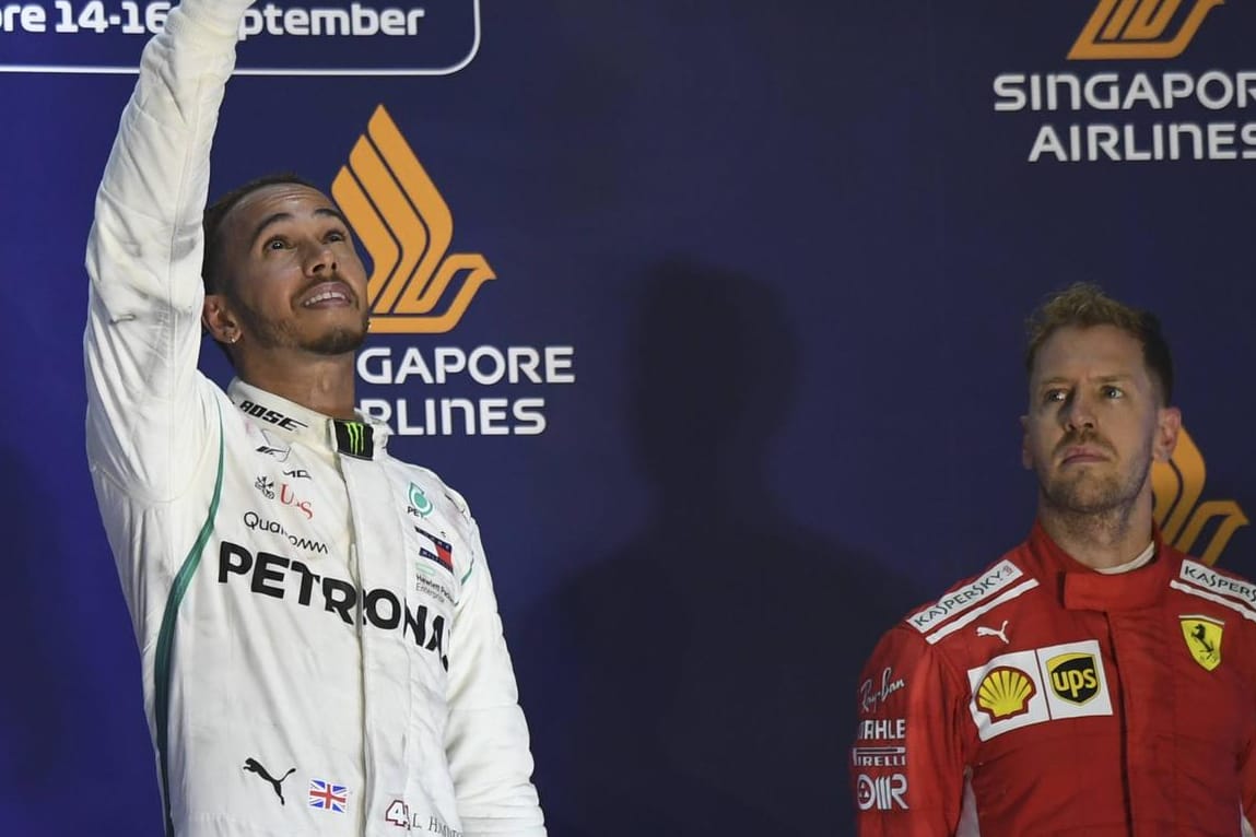 Auf dem Podium in Singapur: Lewis Hamilton (links) feiert seinen siebten Saisonsieg, Sebastian Vettel ist entsprechend niedergeschlagen.