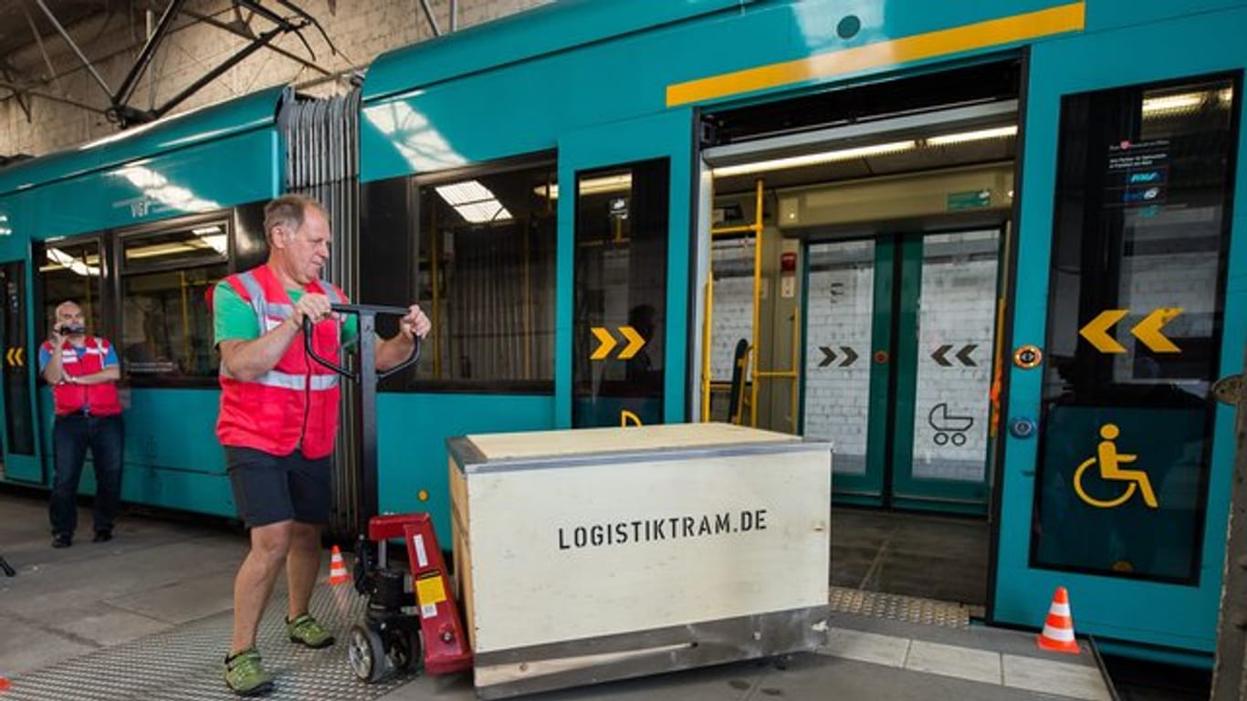 Pilotprojekt "Logistiktram": Eine Transportbox wird auf dem VGF Betriebshof Gutleut mit einem Hubwagen in eine Straßenbahn geschoben.