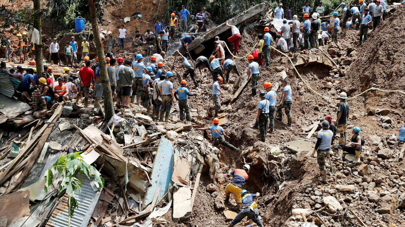 Retter suchen in Itogon auf den Philippinen nach Vermissten: Taifun "Mangkhut" hat mit Schlamm und Schutt eine Unterkunft von Bergarbeitern verschüttet.