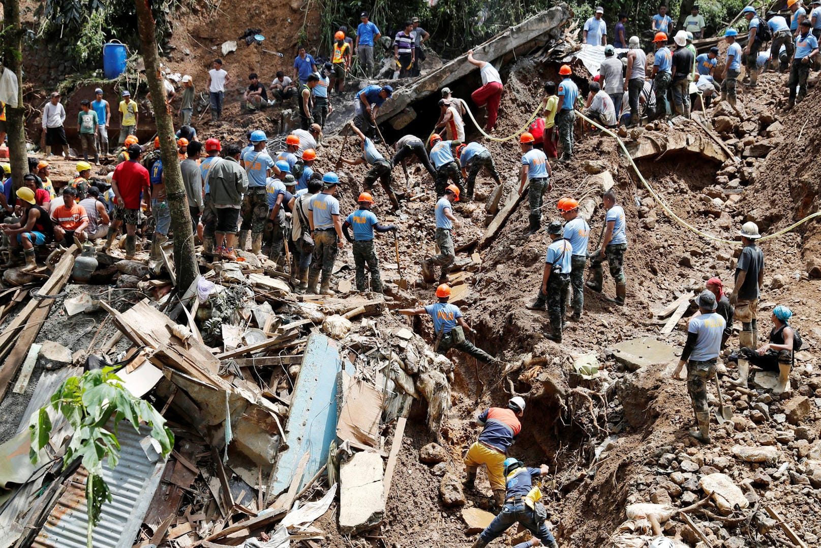Retter suchen in Itogon auf den Philippinen nach Vermissten: Taifun "Mangkhut" hat mit Schlamm und Schutt eine Unterkunft von Bergarbeitern verschüttet.