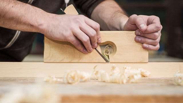 Mann arbeitet mit Handhobel