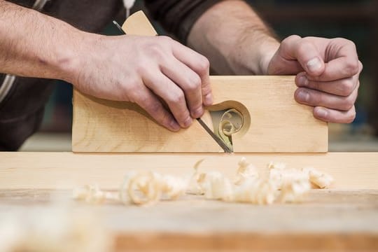 Mann arbeitet mit Handhobel