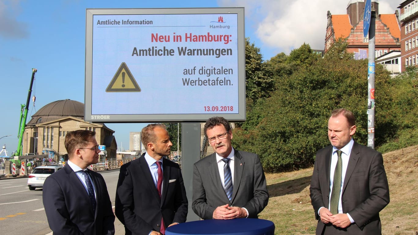 Amtliche Gefahrenwarnungen laufen in Hamburg ab sofort auch auf digitalen Werbeträgern. Dennis Pallasch, Alexander Stotz, Christoph Unger und Andy Grote geben den Startschuss rechtzeitig zum Beginn der Sturmflutsaison.
