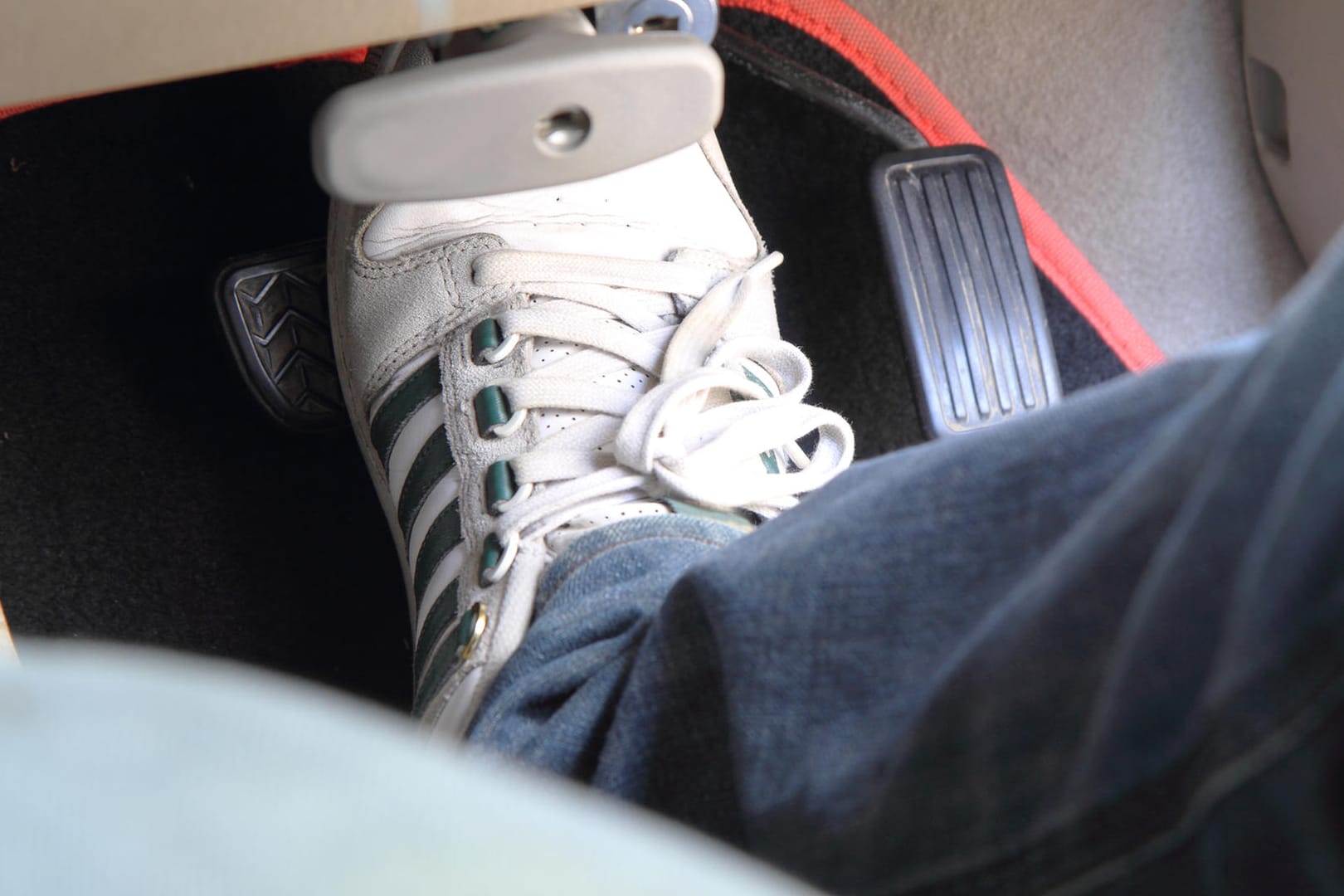 Schuh auf Bremspedal im Auto