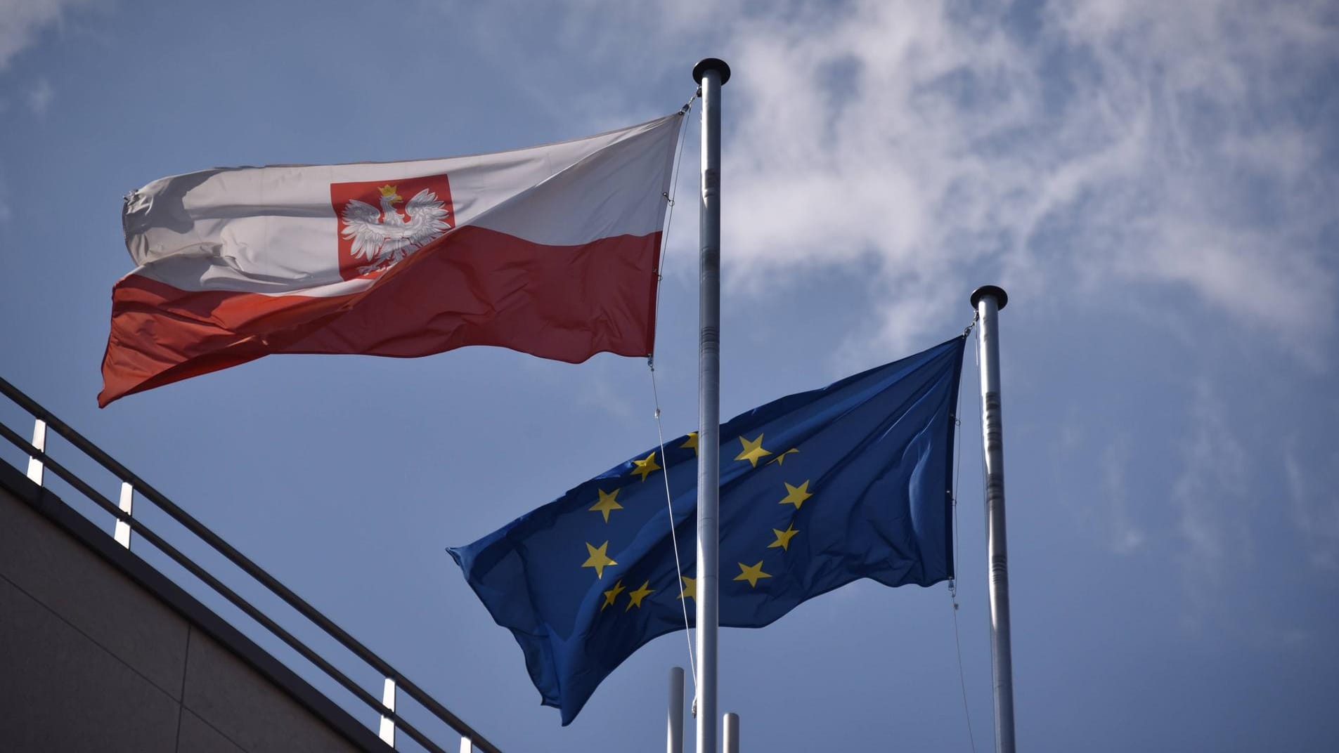 Eine Europa- und eine polnische Flagge auf einem Gebäude: Deutschland und Frankreich wollen am Strafverfahren gegen Polen festhalten. Osteuropäische Länder sehen das kritisch. Eine Europa- und eine polnische Flagge auf einem Gebäude: Deutschland und Frankreich wollen am Strafverfahren gegen Polen festhalten. Osteuropäische Länder sehen das kritisch.