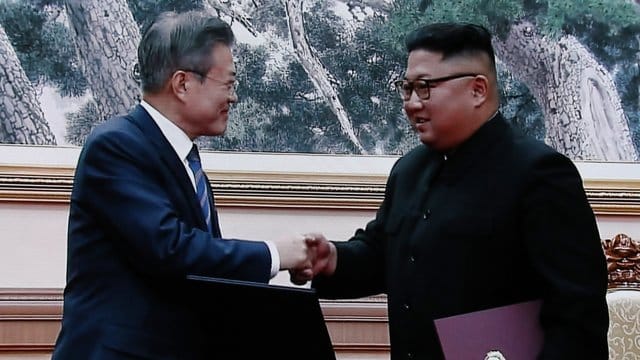 Moon Jae In und Kim Jong Un geben sich nach der Unterzeichnung der Dokumente die Hand. Moon Jae In und Kim Jong Un geben sich nach der Unterzeichnung der Dokumente die Hand.
