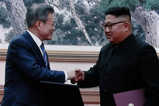 Moon Jae In und Kim Jong Un geben sich nach der Unterzeichnung der Dokumente die Hand.
