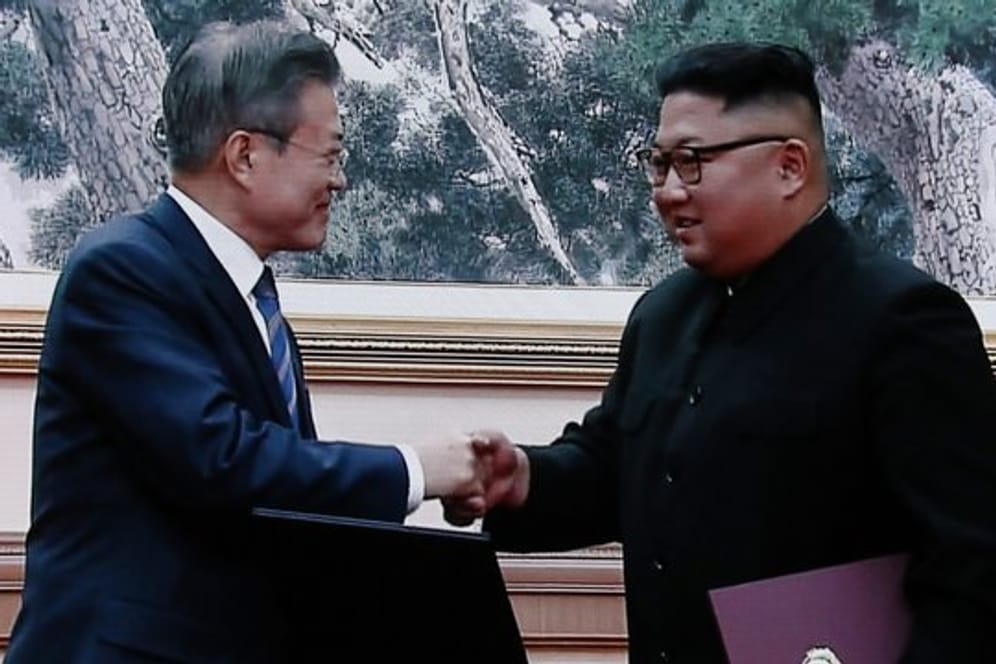 Moon Jae In und Kim Jong Un geben sich nach der Unterzeichnung der Dokumente die Hand.