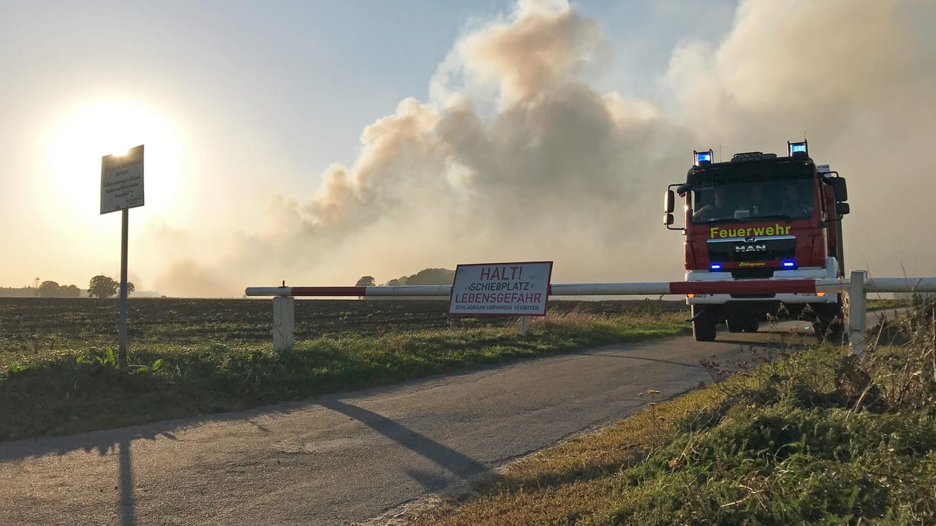 Meppen: Ein Löschfahrzeug der Feuerwehr steht an einer Schranke zum Testgelände der Bundeswehr. Dort stehen seit dem 4. September fünf Hektar Moorland in Brand.