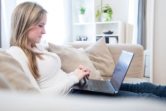 Frau mit Laptop: Für den Alltag daheim, aber auch für Büroarbeiten, genügt oft ein gebrauchtes Notebook um die 300 Euro.