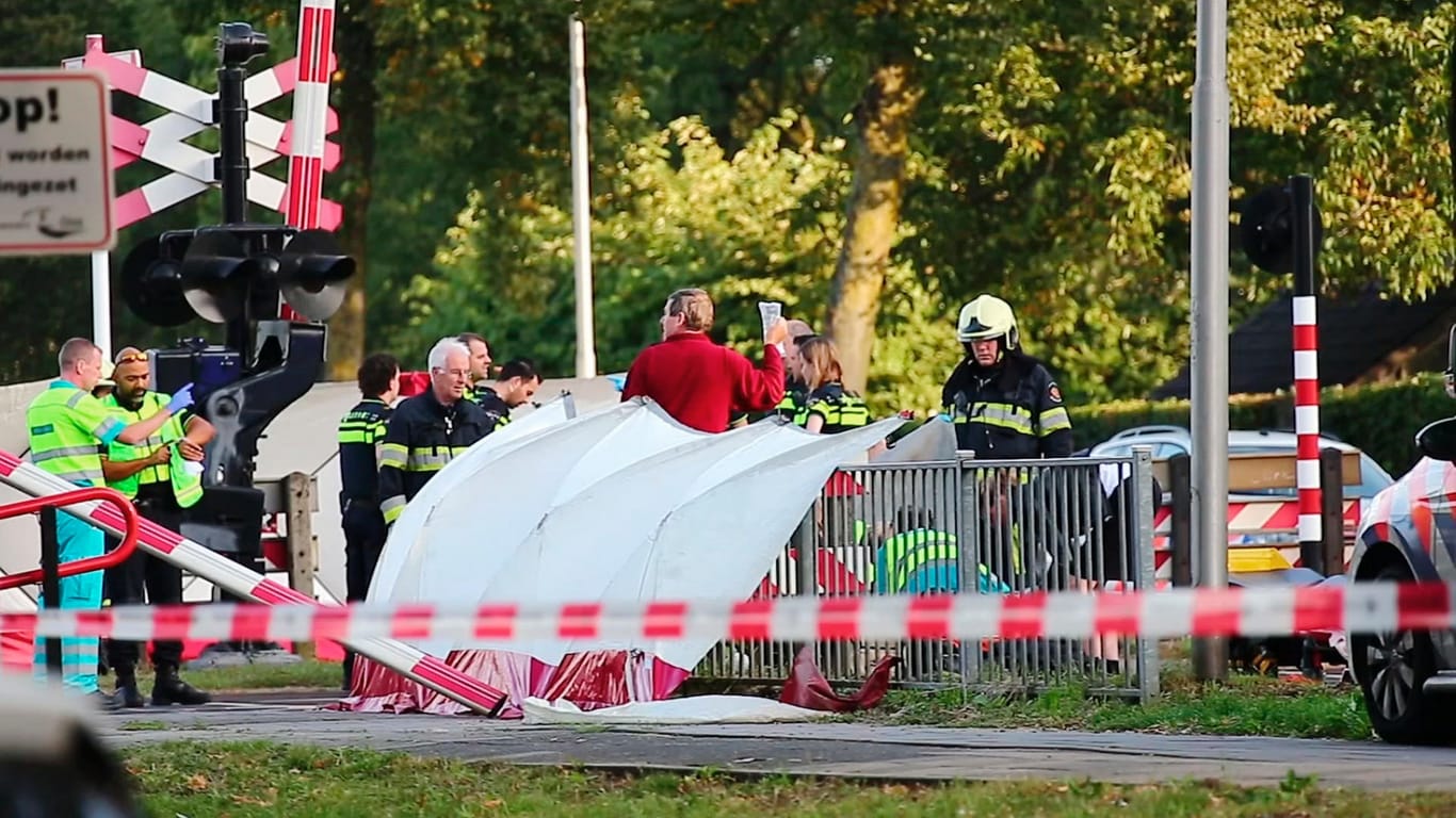 Rettungskräfte am Unfallort: Aus bisher unbekannter Ursache war das elektrische Fahrrad bei einem Bahnübergang im Südosten der Niederlande mit dem Zug zusammengeprallt.