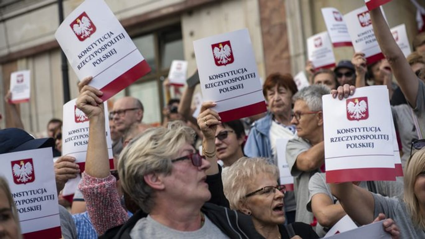 Protest gegen Zwangspensionierungen von Richtern: Demonstranten halten Deckblätter der polnischen Verfassung in ihren Händen.