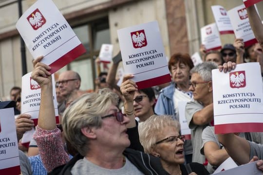 Protest gegen Zwangspensionierungen von Richtern: Demonstranten halten Deckblätter der polnischen Verfassung in ihren Händen.