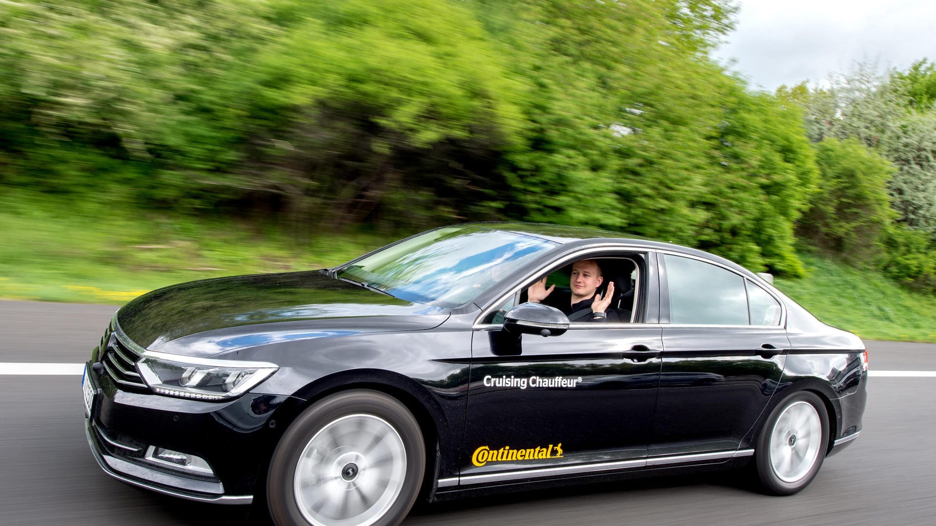 Testingenieur Dennis Scholl fährt in einem Auto mit dem von Continental entwickelten System «Cruising Chauffeur» über die Autobahn A2 und hebt dabei die Hände.