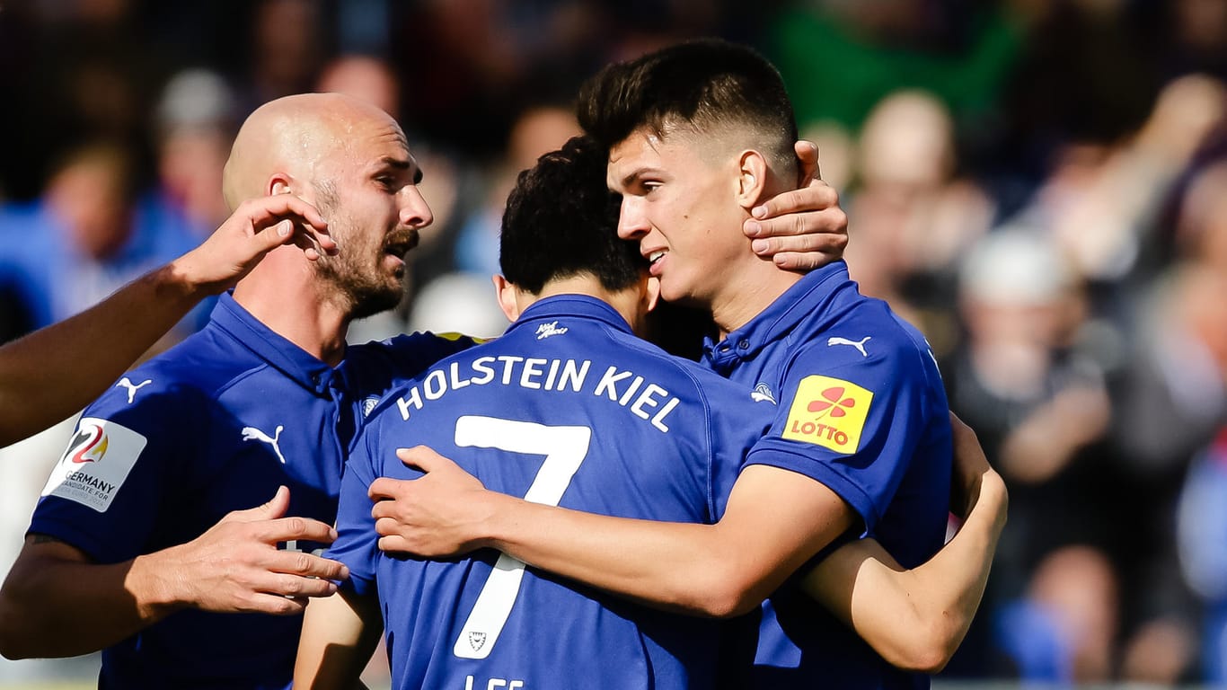 Holstein Kiel - VfL Bochum: Die Kieler Spieler Patrick Herrmann (v.l.), Jae-Sung Lee und Mathias Honsak bejubeln Honsacks Treffer zum 1:1.