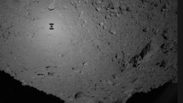 Dieses Bild der Japan Aerospace Exploration Agency (JAXA) zeigt den Schatten der Raumsonde Hayabusa 2 über dem Asteroiden Ryugu. Dieses Bild der Japan Aerospace Exploration Agency (JAXA) zeigt den Schatten der Raumsonde Hayabusa 2 über dem Asteroiden Ryugu.