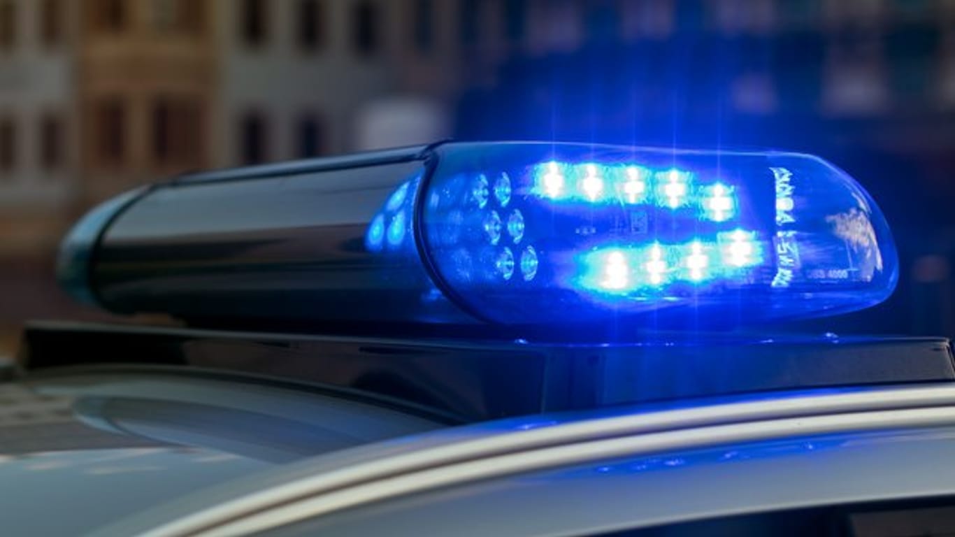 Das Blaulicht auf einem Fahrzeug der Polizei leuchtet in der Dunkelheit.
