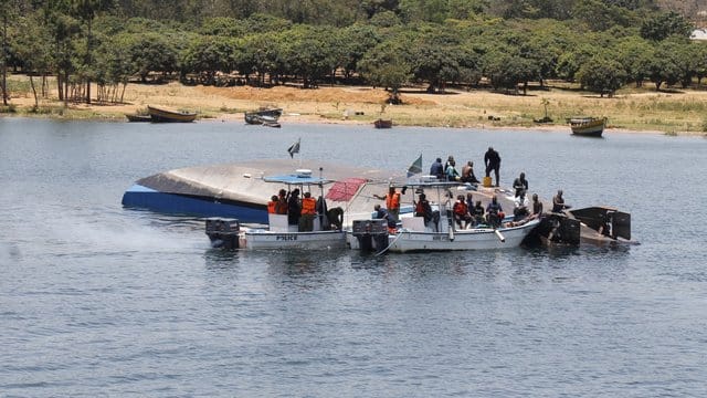 Rettungskräfte sind am Unglücksort neben der gekenterten Fähre im Einsatz.