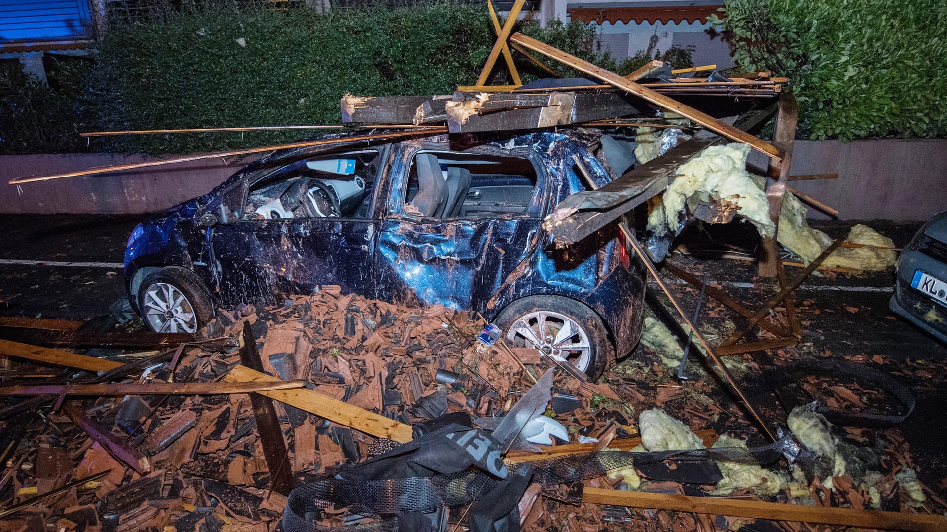 Hessen, Rödermark: Ein schwer beschädigtes Auto steht in einem Wohngebiet. Nach Aussage eines Anwohners hat eine sehr starke Windböe Teile eine Wohnhausdaches mit sich gerissen und auf die gegenüberliegen Strassenseite geschleudert.