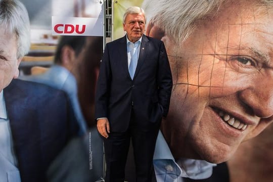 Hessens Ministerpräsident Volker Bouffier posiert in Wiesbaden zwischen den Wahlplakaten.