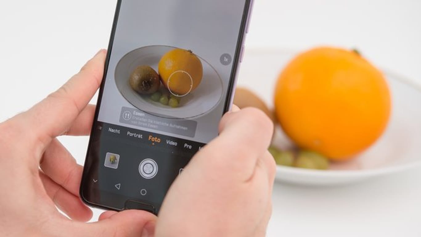 Die Künstliche Intelligenz in diesem Huawei Smartphone erkennt die Orange und richtet die Kamera für ein ansprechendes Food-Foto ein.