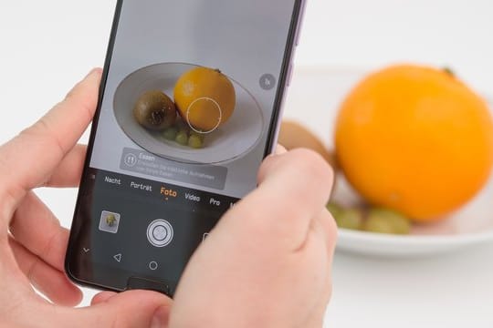 Die Künstliche Intelligenz in diesem Huawei Smartphone erkennt die Orange und richtet die Kamera für ein ansprechendes Food-Foto ein.