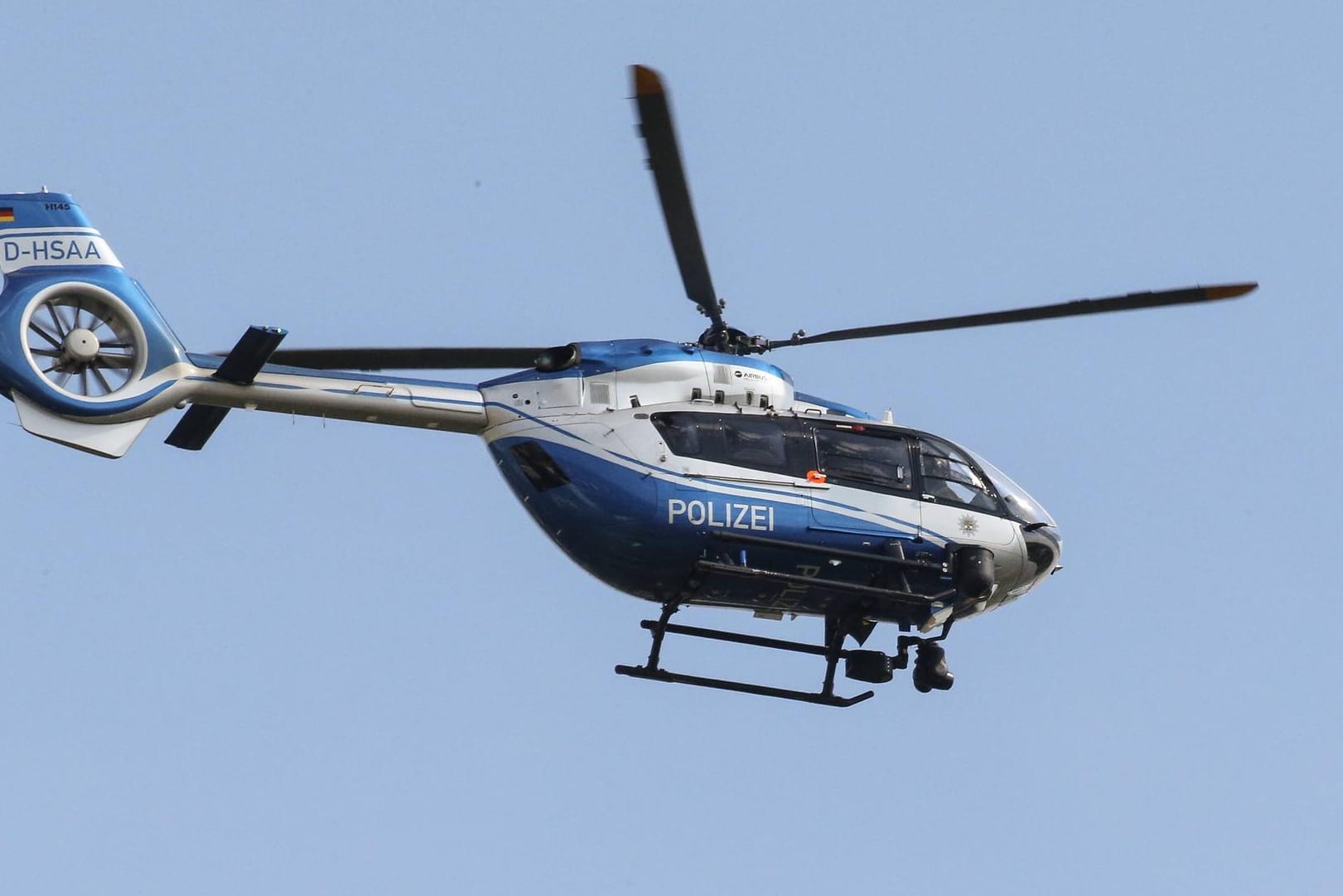 Polizeihubschrauber im Einsatz: Die Beamten gehen immer noch davon aus, dass der Mann mit einem Beil bewaffnet ist. (Symbolbild)
