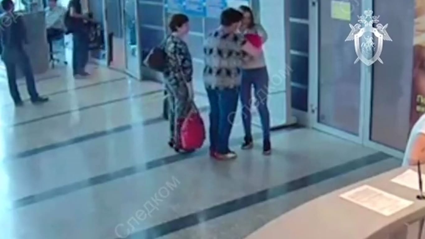 Video vom Flughafen: Eine 25-Jährige übergibt ihr Neugeborenes einer Lehrerin (Mitte). Eine ältere Frau hat sie zur Übergabe begleitet (links).