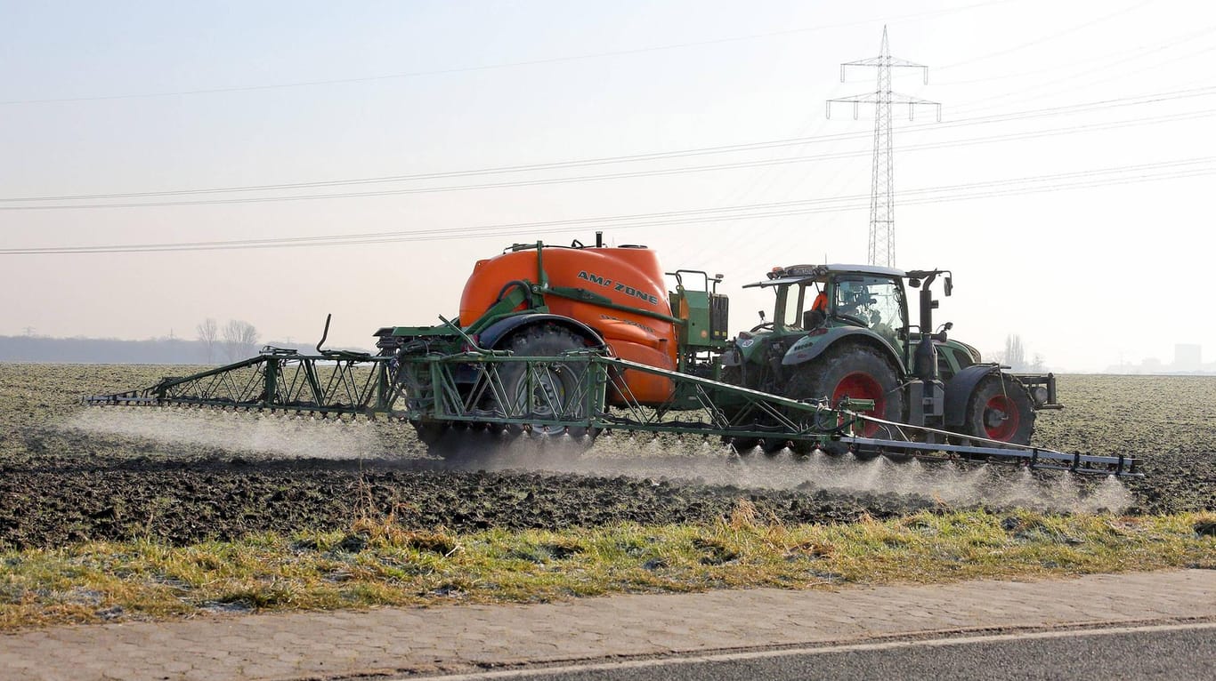 Ein Traktor zieht die Feldspritze über den Acker: Der Unkrautvernichter Glyphosat steht unter Verdacht Bienen zu schädigen.