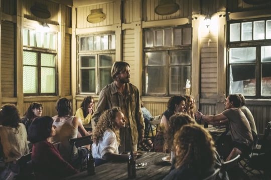 Kruso (Albrecht Schuch) und Karola (Anja Schneider) mit den "Schiffbrüchigen" auf der "Klausner"-Terrasse.