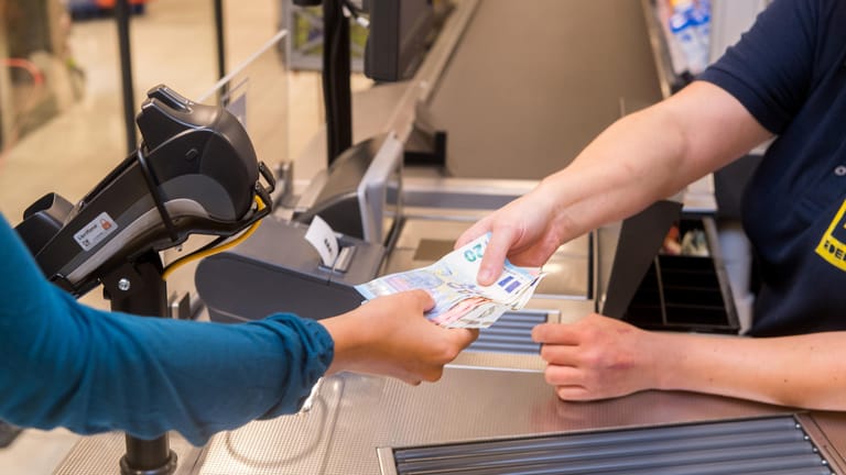 Kunde erhält Bargeld: In vielen Supermärkten kann man beim Bezahlen inzwischen auch Geld abheben.