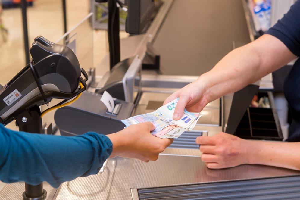 Kunde erhält Bargeld: In vielen Supermärkten kann man beim Bezahlen inzwischen auch Geld abheben.