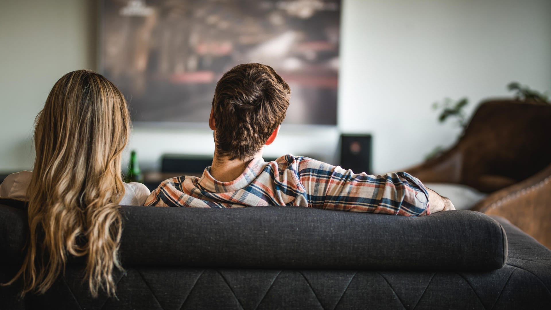 Pärchen beim Fernseh-Gucken (Symbolbild): Wer sich unsicher ist, welche TV-Größe für den eigenen Bedarf passend ist, kann sich mit einem Pappen-Test behelfen