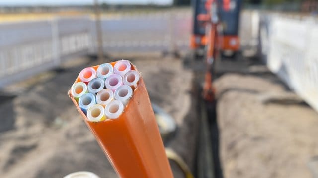 Farbige Leerrohre, in die später die Glasfaserkabel verlegt werden, ragen aus einem Graben auf einer Baustelle im brandeburgischen Grassau. Farbige Leerrohre, in die später die Glasfaserkabel verlegt werden, ragen aus einem Graben auf einer Baustelle im brandeburgischen Grassau.