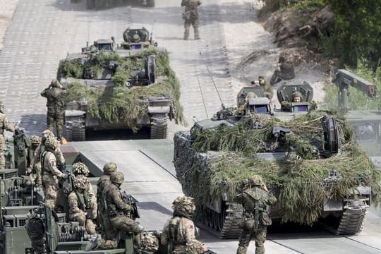 Bundeswehrsoldaten überqueren während eines Nato-Manövers in Litauen auf einer Pontonbrücke einen Fluß.