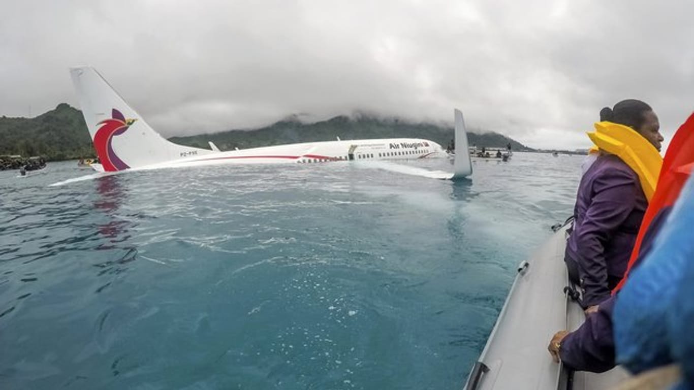 Angehörige der US Navy helfen dabei, Passagiere und Besatzung eines Air-Niugini-Fluges an Land zu bringen.