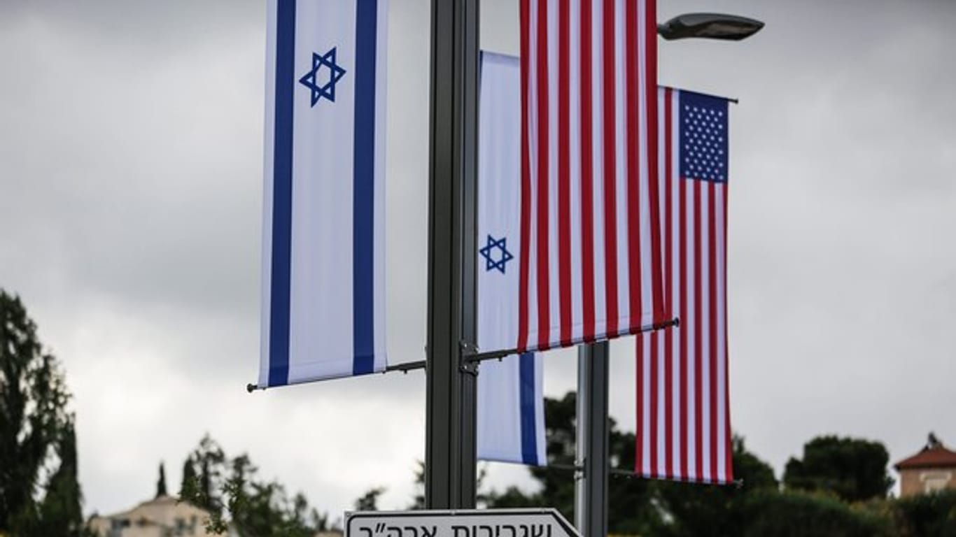 Eine Israelische und US-Flagge sind über einem Schild angebracht, das den Weg zur Botschaft der USA weist (Archiv).