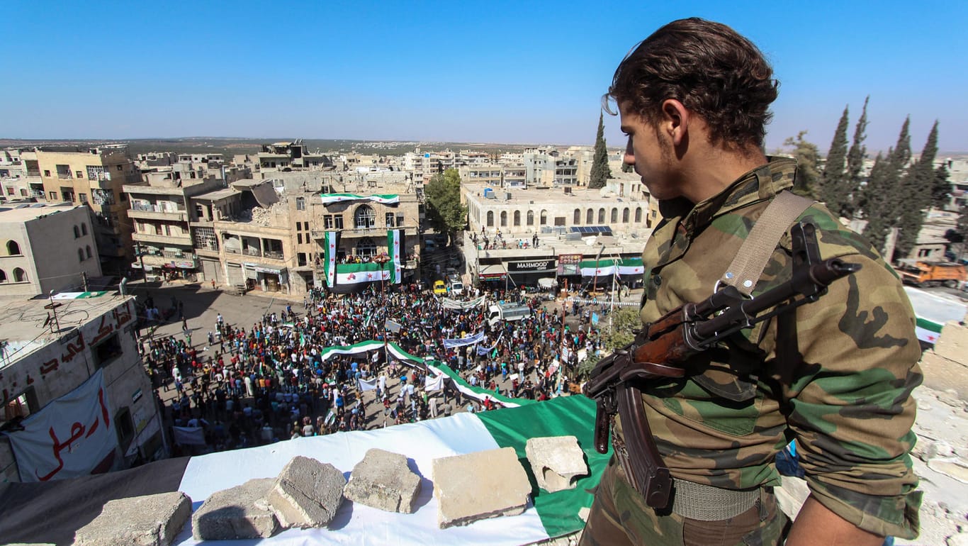 Syrischer Soldat in Ariha bei Idlib: Auf der Straße fordern Demonstranten die Freilassung von Gefangenen aus der Haft des Assad-Regimes.