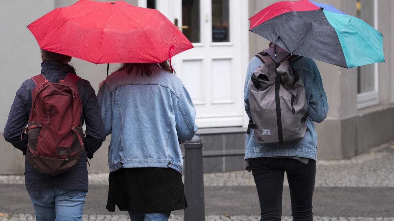 Junge Frauen mit Regenschirmen in Berlin: Der Oktoberbeginn wird in ganz Deutschland ungemütlich.