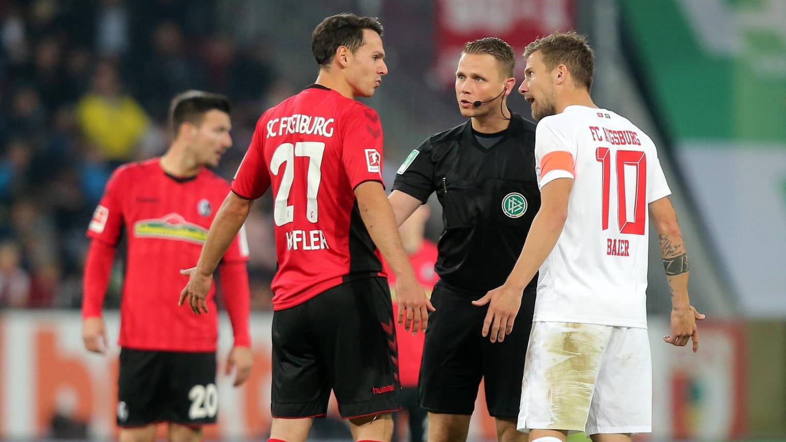 Freiburgs Höfler (l.) spricht mit Gegenspieler Baier und Schiedsrichter Kampka: Immer wieder gab es in der umkämpften Partie hitzige Diskussionen.