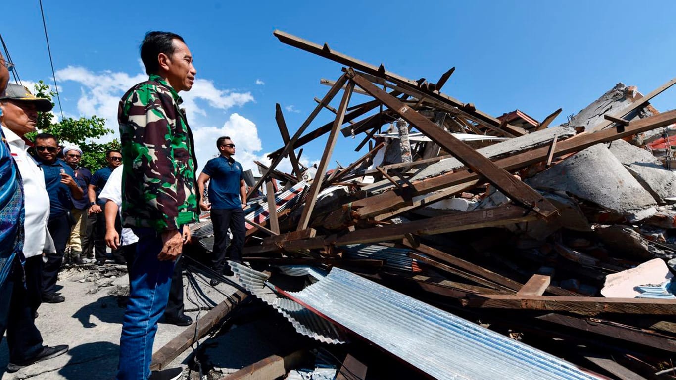 Der indonesische Präsident Joko Widodo geht durch eine beschädigte Gegend: Bei der Tsunami-Katastrophe in Indonesien sind vermutlich mehr als tausend Menschen ums Leben gekommen.