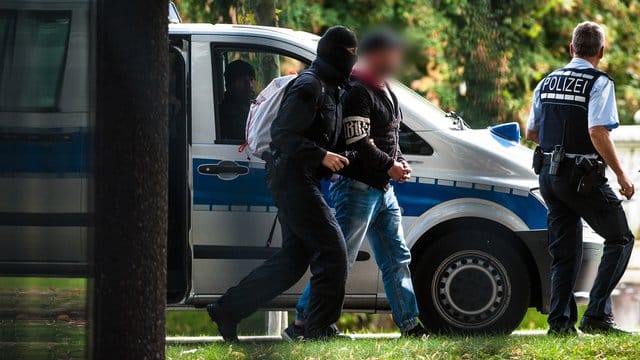 Einer der Verdächtigen wird vor dem Bundesgerichtshof in Karlsruhe von Polizisten abgeführt.