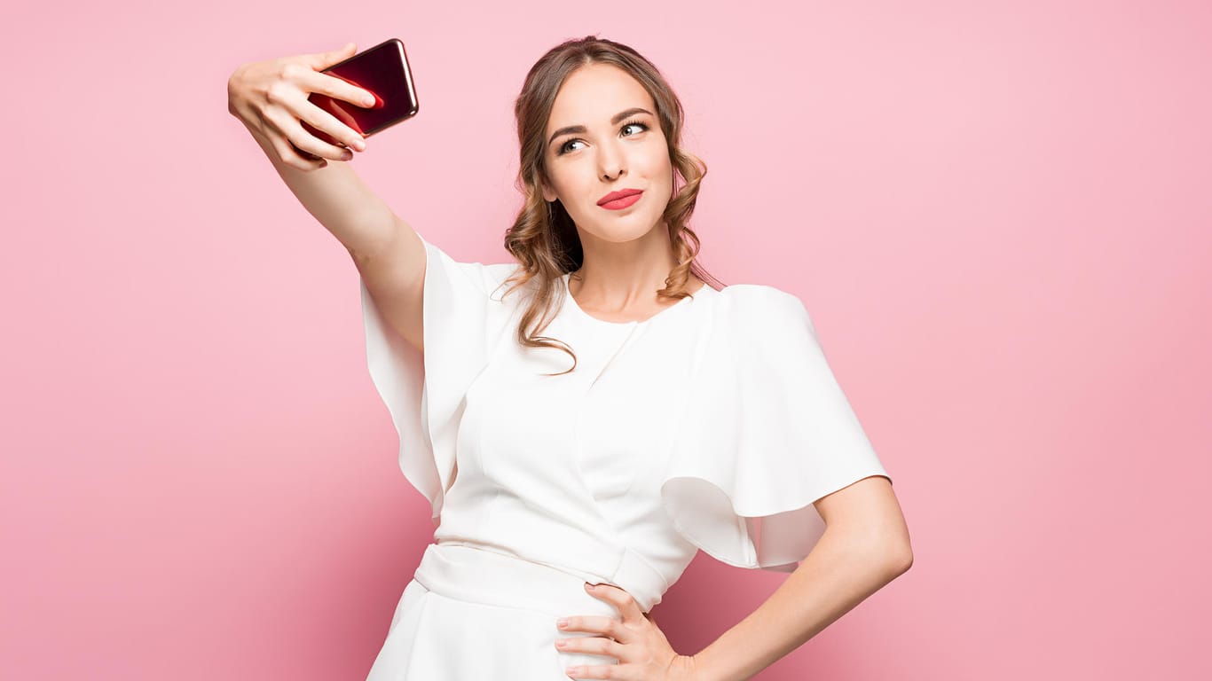 Eine junge Frau posiert für ein Selfie: Das neue iPhone setzt bei Selfies einen Standard-Beautyfilter ein. Das Ergebnis gefällt nicht jedem.