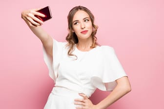 Eine junge Frau posiert für ein Selfie: Das neue iPhone setzt bei Selfies einen Standard-Beautyfilter ein. Das Ergebnis gefällt nicht jedem.