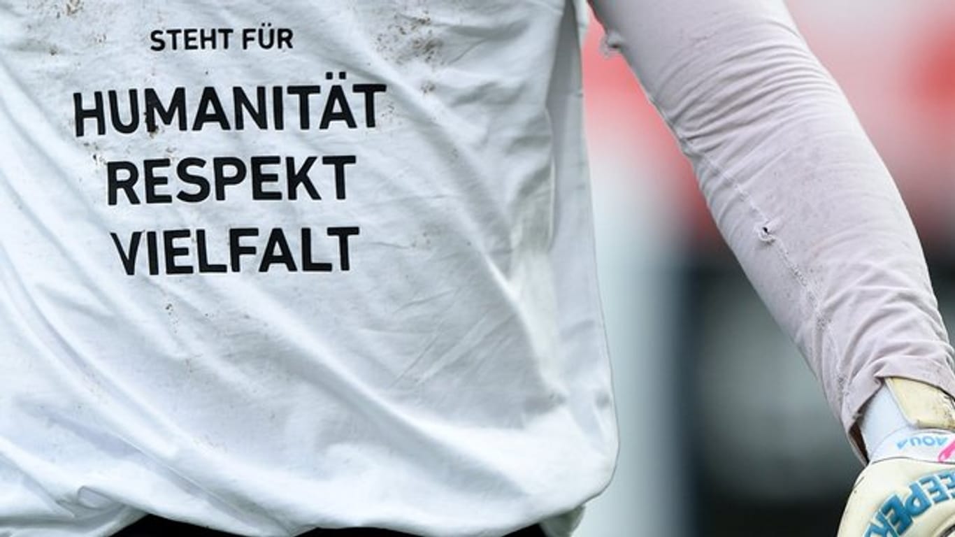 Immer wieder daran erinnern: Spieler von Fortuna Düsseldorf tragen zum Aufwärmen ein T-Shirt mit der Aufschrift "Humanität - Respekt - Vielfalt".