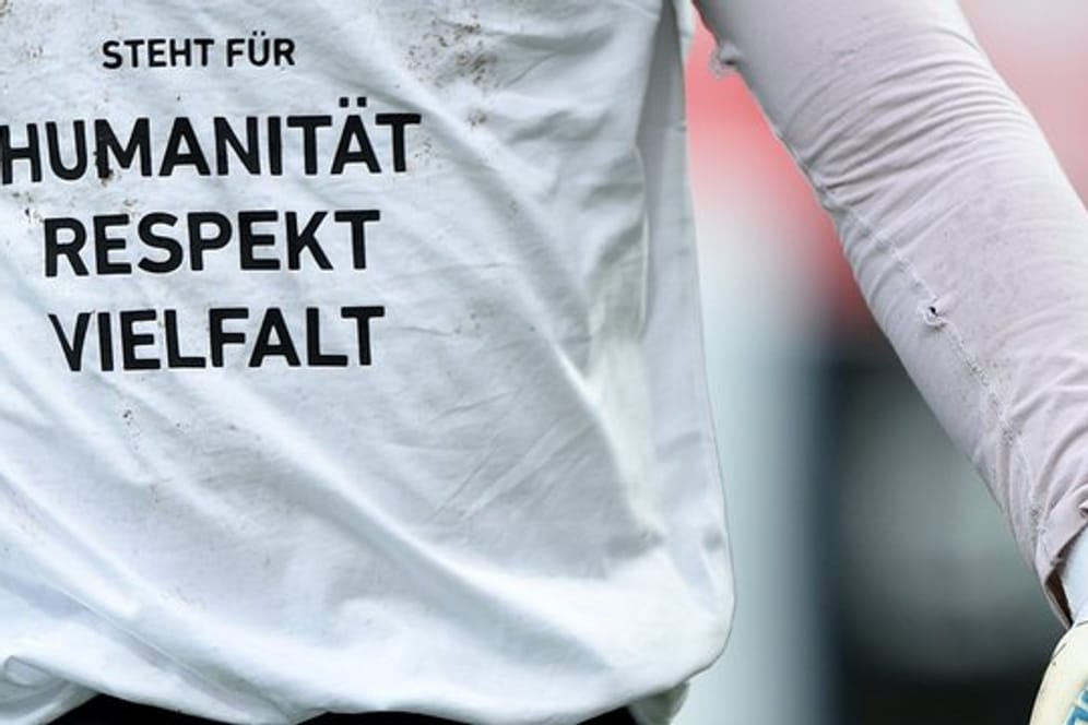 Immer wieder daran erinnern: Spieler von Fortuna Düsseldorf tragen zum Aufwärmen ein T-Shirt mit der Aufschrift "Humanität - Respekt - Vielfalt".