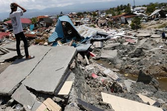 Indonesien, Palu: Zwei Männer überblicken die Schäden nach den Erdbeben und dem Tsunami. Nach einer offiziellen Zwischenbilanz kamen bei der Serie von Beben und dem folgenden Tsunami an der Westküste Sulawesis mehr als 1200 Menschen ums Leben.