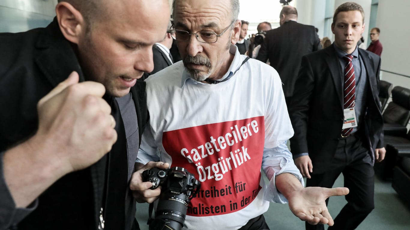 Adil Yiğit, der ein T-Shirt mit der Aufschrift "Pressefreiheit für Journalisten in der Türkei" trägt, wird im Bundeskanzleramt aus der gemeinsamen Pressekonferenz von Merkel und Erdogan geführt.