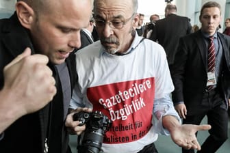 Adil Yiğit, der ein T-Shirt mit der Aufschrift "Pressefreiheit für Journalisten in der Türkei" trägt, wird im Bundeskanzleramt aus der gemeinsamen Pressekonferenz von Merkel und Erdogan geführt.