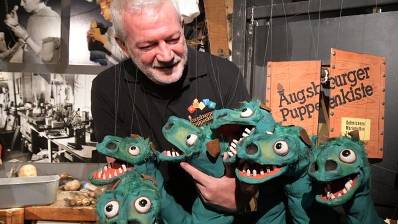 Der Leiter der Augsburger Puppenkiste, Klaus Marschall, zeigt ein mehrköpfiges Marionettenungeheuer.